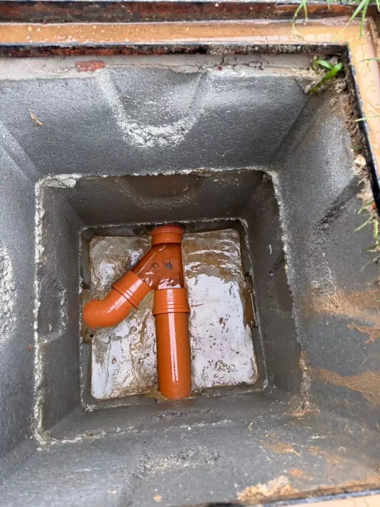 Chambre de visite ouverte et raccord PVC dégagé à Auderghem